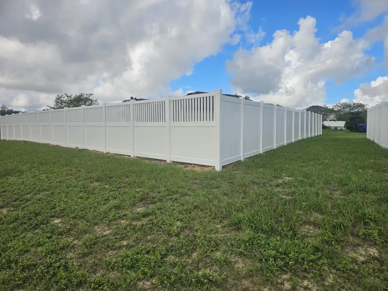 White vinyl privacy fence with open lattice top enclosing a large Central Florida lot
