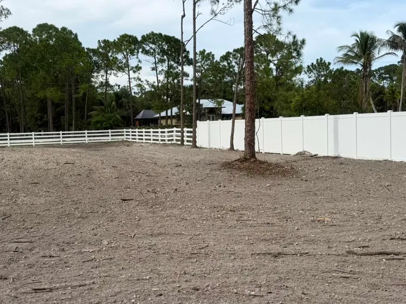 White vinyl ranch rail fence meeting a vinyl privacy section on an acreage lot