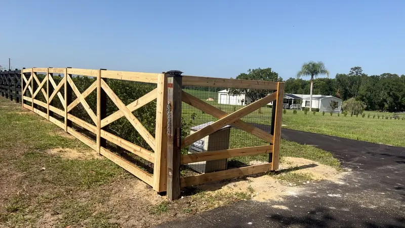 Crossbuck ranch fence with matching driveway gate at a rural Florida property entrance
