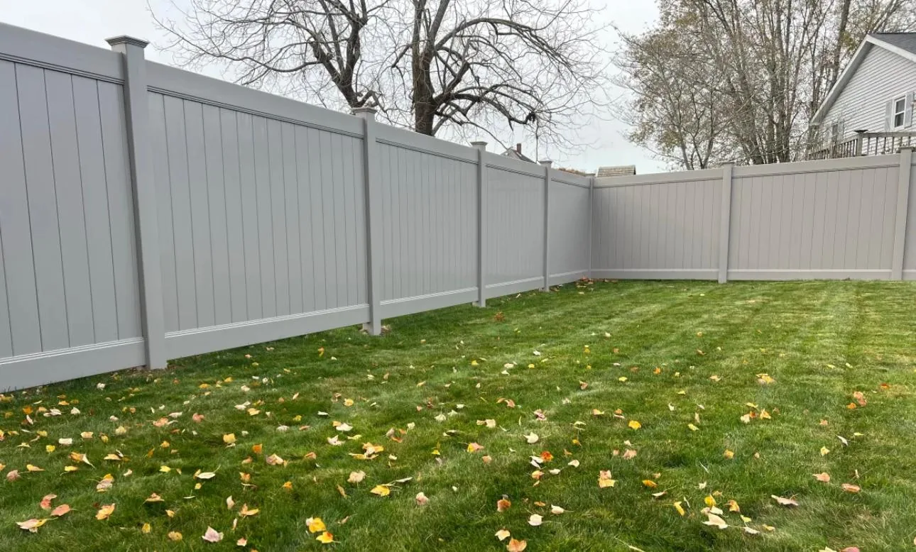 Gray vinyl privacy fence with vertical boards installed along a Florida residential property line